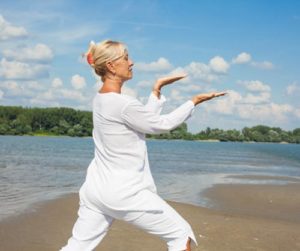 Frau macht Tai-Chi am Strand